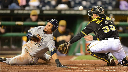 The Brewers' Carlos Gomez slides past the tag of Pirates catcher Michael McKenry.