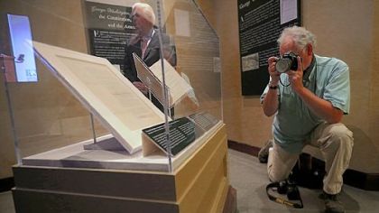 A member of the news media photographs President George Washington's personally annotated copy of the Acts of Congress on Monday in Mount Vernon, Va.