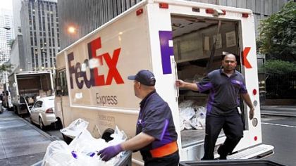 FedEx employees deliver packages in New York. FedEx is cutting its earnings expectations for the fiscal year ending in May due to slowing global economic growth.