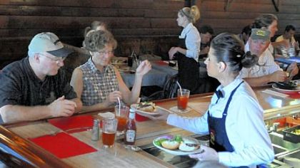 Tom and Joan Ashton from Bethlehem, Pa., are served their Tessaro's burgers at the bar by bartender Jessica Brandstadter.