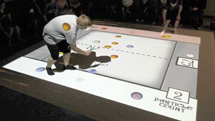 Eighth-grader Ethan McLay tries his hand at playing SMALLab's "consumers and producers" game. SMALLab software can create a variety of games, then project them onto an interactive screen on the floor.