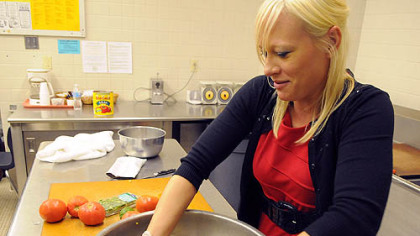 Jennifer Reiser mixes black bean corn salsa in the kitchen at Quaker Valley's Anthony Wayne Middle School. New federal school lunch regulations are changing how cafeteria workers prepare and present food, such as creating eye-catching displays to entice students.