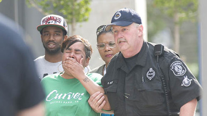 Police escort a woman identified as the mother of Klein Michael Thaxton, into 3 Gateway Center this morning. Police say Thaxton is the the man holding a hostage on the 16th floor of Number 3 Gateway Center.