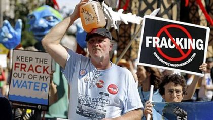 Ray Kemble of Dimock, Pa., on Thursday marches with a jug of his well water outside a Marcellus Shale industry conference where Gov. Tom Corbett attacked anti-drilling activists as the "unreasoning opposition."