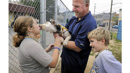 new member of the family Oscar, a puppy found last month in a garbage can in Garfield, plants a wet one on Ryleigh Long, 10, at the Animal Rescue League Shelter & Wildlife Center in East Liberty on Friday. The Long family of West Deer ? including Dave, center, Noah, right, and Wendy, not pictured ? have adopted the mutt.