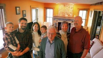 From left: Ryan holds 4-year-old Jacob while Marlene holds 2-year-old Noah. Elaine and Brad Wise are at the right and John Wise is at center in the living room of the Wise home.