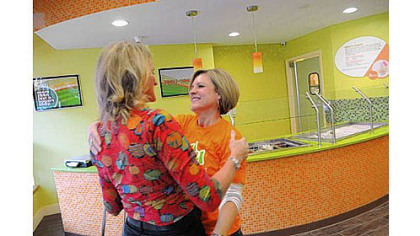 Ellie Hall, right, embraces Lynne Jones of Colorado as they prepare to open Yogli Mogli yogurt shop on Washington Road in Mt. Lebanon Saturday. Ms. Hall is the widow of the late Brian Hall, co-owner of the business, who died recently in a small plane crash. Ms. Jones is the wife of the other co-owner.
