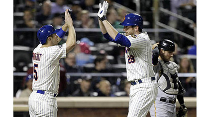 The Mets' David Wright, left, greets Ike Davis at the plate as Pirates catcher Michael McKenry adjusts his helmet after Wright scored on an Ike Davis two-run home run in the fourth inning.