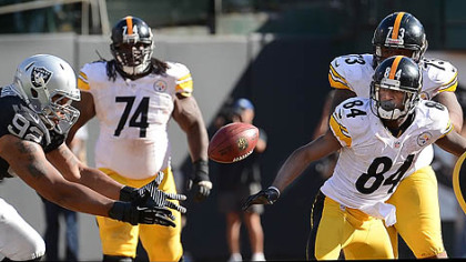 The Steelers' Antonio Brown can only watch as the Raiders' Richard Seymour makes an interception.