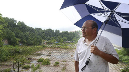 Doug Graham of Bloomfield stands in front of an eight-acre vacant hole in the ground near his house. Originally, the site was going to be a $115 million development, but it is now scheduled to be a 1,000-car UPMC garage.