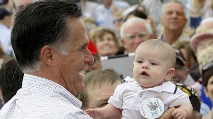 Mitt Romney picks up a baby wearing a "Dump Obama" pin as he campaigns in Pueblo, Colo.