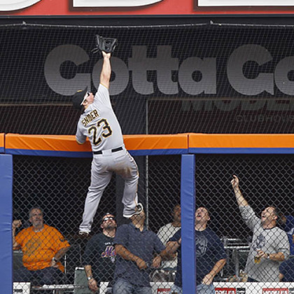 Pittsburgh Pirates right fielder Travis Snider climbs the fence to rob New York Mets' Mike Baxter of a home run during the second inning.