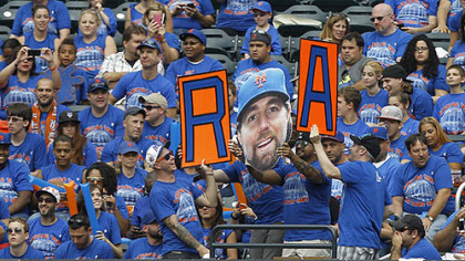 Fans pay tribute to New York Mets pitcher R.A Dickey, who is going for his 20th victory, during a baseball game against the Pittsburgh Pirates at Citi Field in New York.