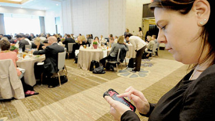 Amie Downs sends tweets Wednesday from Allegheny County Executive Rich Fitzgerald's talk to property agents before the Downtown Real Estate Tour at the Fairmont Hotel.