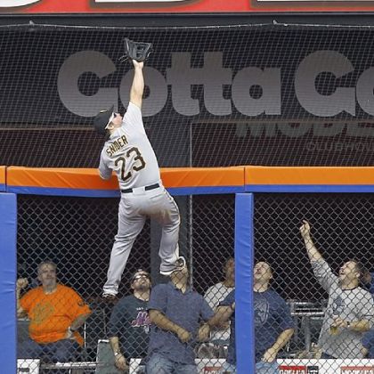 Travis Snider climbs the fence to rob the Mets' Mike Baxter of a home run Thursday at Citi Field in New York.