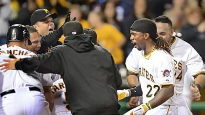 Pirates outfielder Andrew McCutchen is greeted at home after hitting a walk-off homer against the Reds in the ninth inning Saturday night at PNC Park.