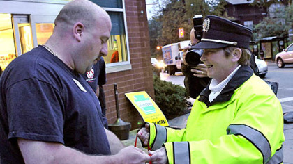 Maureen Twigg, crossing guard at the corner of Murray and Forbes Avenues in Squirrel Hill, receives a wellness package today from Jeff Suriano, who ovesees the 19 Rite Aids in the city.