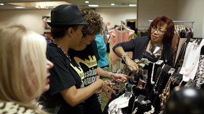 Attendees gather around the Traci Lynn Jewelry booth at the Fashion Ave Vendors Fair at the Clarion Hotel & Convention Center in Green Tree.