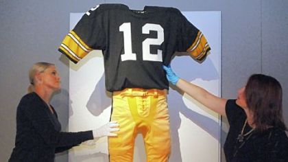 Heinz History Center's Courtney Keel, left, and Paula Andras smooth the wrinkles out of Terry Bradshaw's 1970s uniform as the NFL Hall of Fame exhibit nears completion. The exhibit opens Saturday.