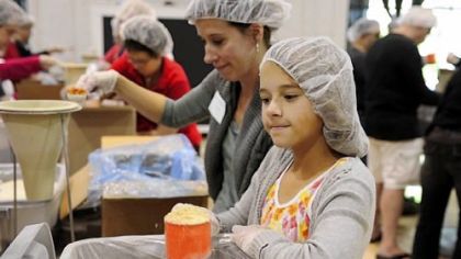 Ainsley Kasper, front, and her mother, Michele Kasper, were among those who packed food items for Stop Hunger Now.