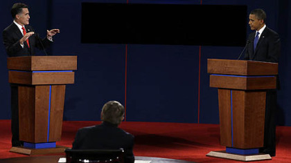 Republican presidential nominee Mitt Romney answers a question while President Barack Obama listens during the first presidential debate at the University of Denver.