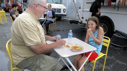 Dave Holcomb and his daughter Hadley, 10, of Ben Avon, enjoy dogs from Franktuary's truck.