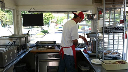 The interior of stand-alone "Streets Food Cart" is spotless stainless steel. The tight quarters
mean that every motion counts.