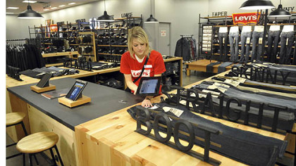 Emily Wasel, a Levi's specialist at the J.C. Penney store in the Mall at Robinson, uses a mobile point-of-sale computer to scan the barcode on a pair of jeans.