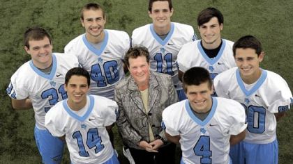 Seneca Valley's Heather Lewis, surrounded by members of the football team, is one of the growing family of female athletic directors in the area.