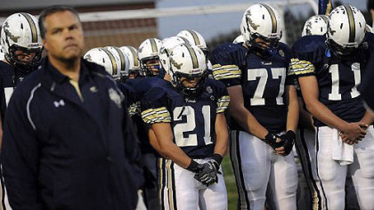 Knoch head coach Michael King leads his team and the crowd in a moment of silence for slain former player Tim McNerney before the start of the game against Franklin Regional Thursday night.