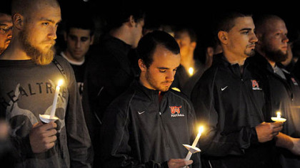 Washington & Jefferson College football players hold candles Thursday night in a vigil for their slain teammate.