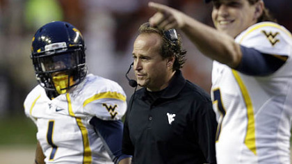West Virginia coach Dana Holgorsen, center, talks to players during a time out.