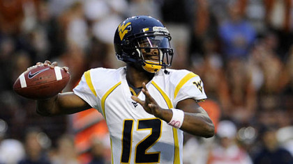 West Virginia quarterback Geno Smith looks for a receiver during the first quarter.