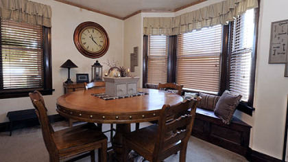 The dining room has a gas fireplace with a large carved oak mantelpiece and mosaic ceramic tile surround.