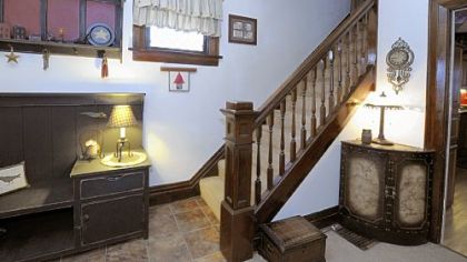 The entryway features the original woodwork on the staircase, windows, baseboards and door frames.