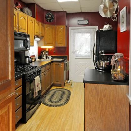 The kitchen has oak cabinets, solid-surface countertops and a wood laminate floor.