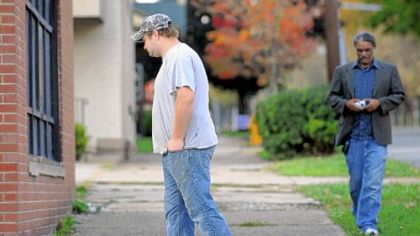 A friend of slain Washington and Jefferson football player Tim McNerney pauses Thursday at the scene of the killing across the street from campus.