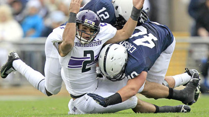 Northwestern quarterback Kain Colter is tackled by Penn State cornerback Stephon Morris and linebacker Glenn Carson (40) as he attempts to catch a pass during the second quarter of today's game in State College.
