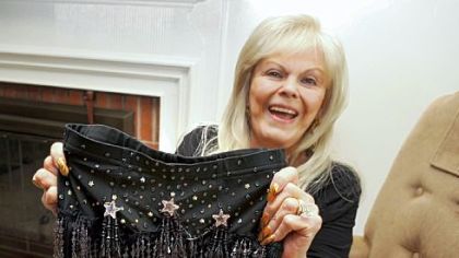 Penny Roberts, 79, poses in her west Allentown living room and shows a short skirt she wears when she performs.