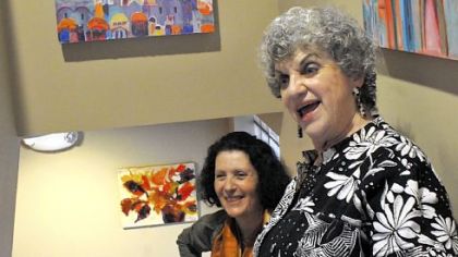 Artist Zivi Aviraz and Lila Hirsch Brody, right, who has taught painting classes at the Jewish Community Center for many years, show off some of Ms. Aviraz's paintings in Jason Kramer Hall, which is home to 10 adults with intellectual disabilities in Squirrel Hill.
