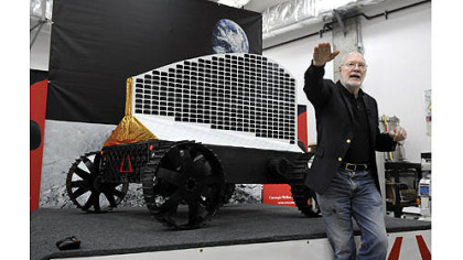 William "Red" Whittaker, CEO of Astrobotic Technology Inc. and founder of the Field Robotics Center at Carnegie Mellon University's Robotics Institute, talks about Polaris, displayed behind him. The solar-powered robot will search for deposits of ice at the moon's poles.