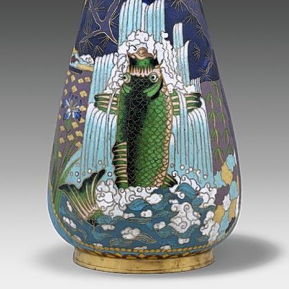 The strong influence of Japanese designs is seen in this vase created in 1875 by Elkington & Co. Made of enamel and gilded brass, it shows a carp against a waterfall framed by pine branches.