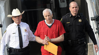 Jerry Sandusky in escorted from the Centre County Courthouse after his sentencing on 45 counts of child sex abuse. Centre County Sheriff Denny Nau is at left.