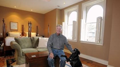 Ty Ely and his dog Bobbie in the master bedroom on the third floor of the Elys' Shadyside home. The king-size bed is made from twin beds Tye's wife Sue inherited from her grandfather.