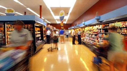 Shoppers check the offerings in a Giant Eagle dairy aisle. The grocer is locking prices on some staples at a time of rising commodity prices.