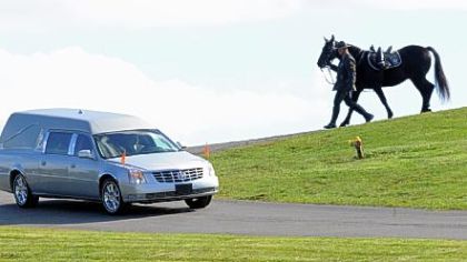 A Trooper leads a horse following the hearse carrying Trooper First Class Blake T. Coble to the graveside ceremony held at St. Mary's Roman Catholic Church Cemetery in Beaver Falls.