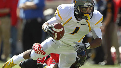West Virginia's Tavon Austin is tackled by Texas Tech's D.J. Johnson.