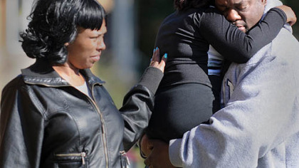 Robert Bailey comforts his daughter, Tasia, a cheerleader for the East End Raiders, following a shooting Saturday morning at a football game against Wilkinsburg at Peabody High School. An unidentified woman offers comfort.
