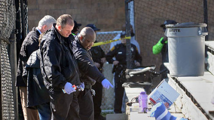 Pittsburgh police investigators look over the scene of a shooting at a peewee football game this morning adjacent to the Pittsburgh Obama International Studies Academy in East Liberty.