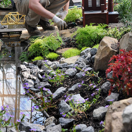 Matt Urian fills in small scenic details in the Garden Railroad at Phipps Conservatory.